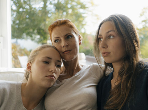 two daughters hugging their mother. image for family cancer support & family cancer