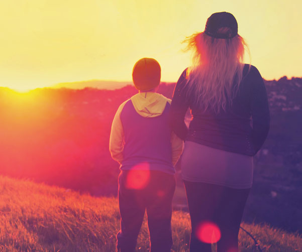image of two members of a family affected by cancer looking into the sunset. 
