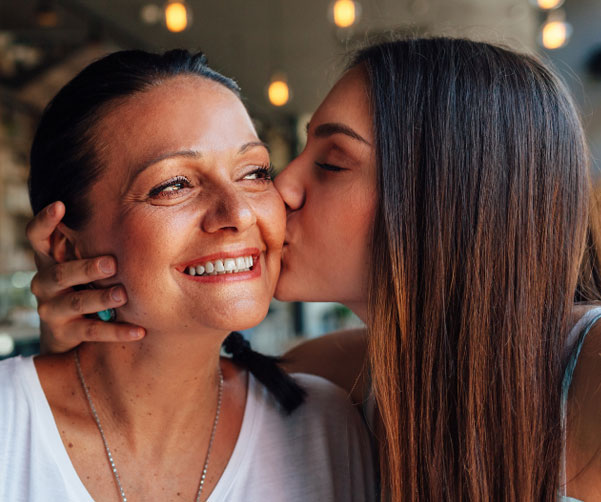 Young woman kissing mother on the cheek