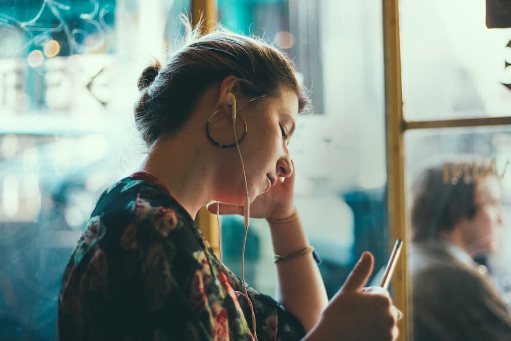 girl listening to podcast on earphones