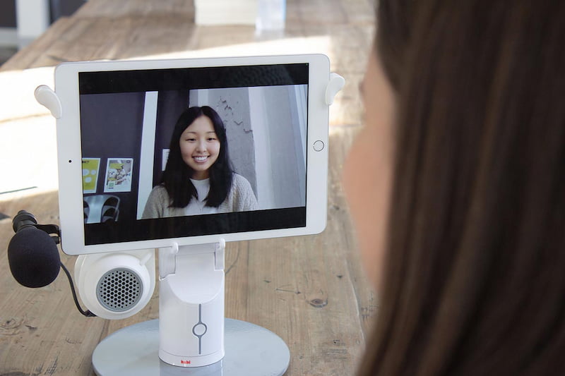 young girl using canteen's robots on an ipad to chat with another person