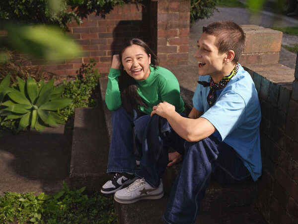 two young people sitting together smiling and chatting