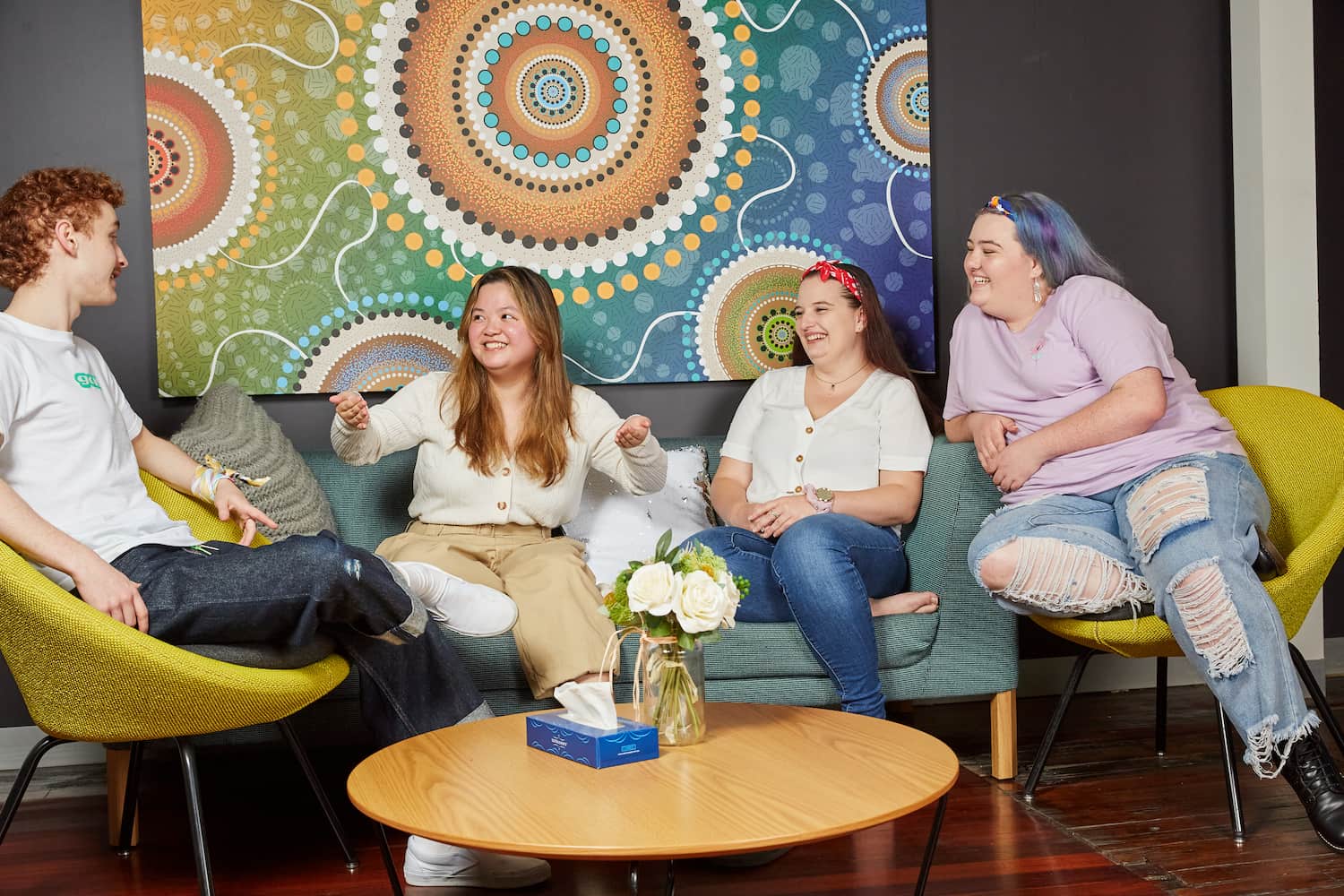group of four people having a conversation in front of an artwork group of four people having a conversation in front of an artwork