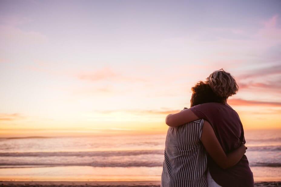 couple standing on beach after cacner diagnosis