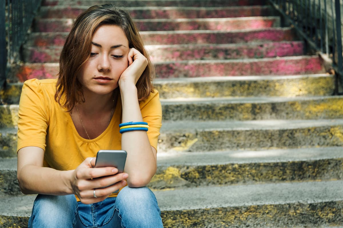 girl dealing with grief looking at phone