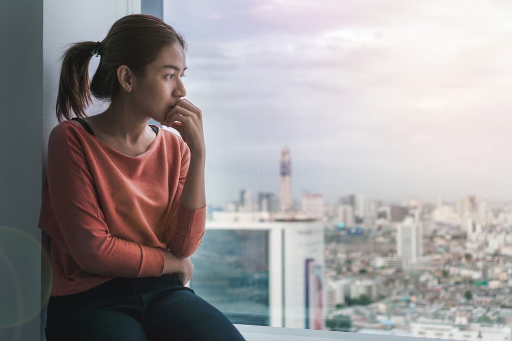 girl looking out of city window