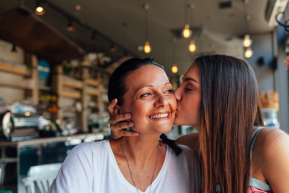 daughter kissing mother