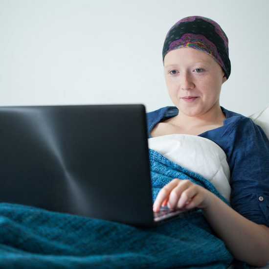 Young woman in hospital bed doing school work