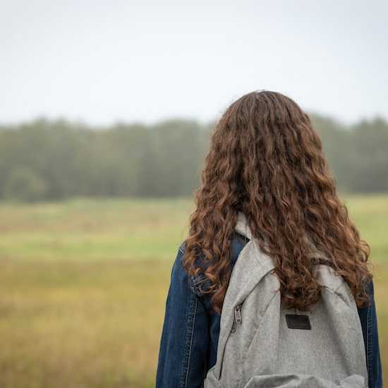 Girl with backpack looking into distance