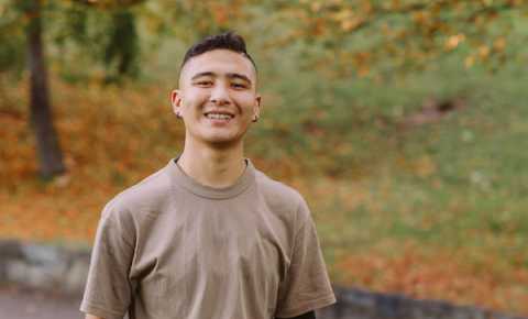 young person smiling in the park