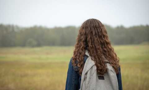 Girl with backpack looking into distance