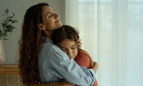 A photograph of a mother hugging her son