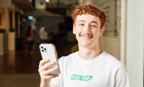 young person on their phone and smiling