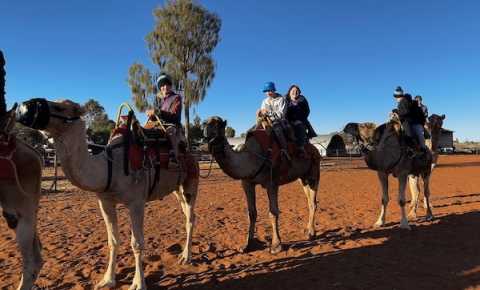 young people riding camels at a canteen event