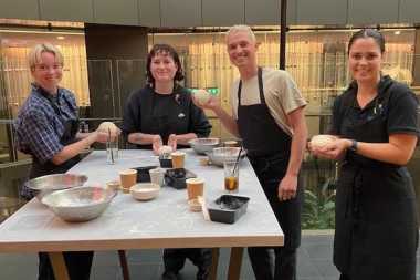 four young people making pizza