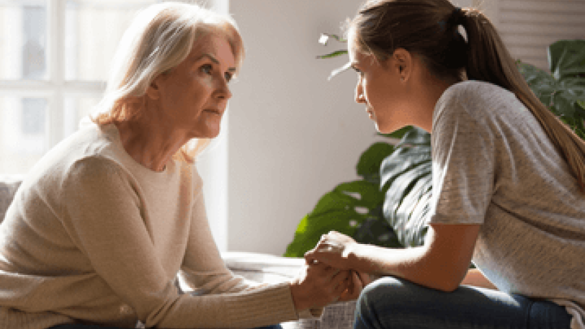 Young woman speaking with her mother about cancer