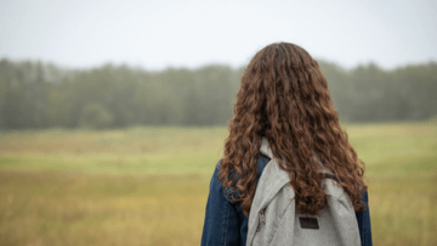 Girl with backpack looking into distance