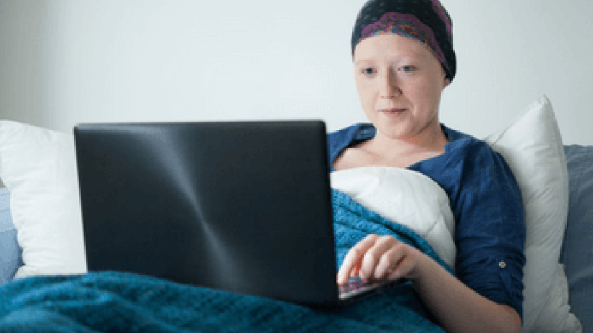 Young woman in hospital bed doing school work