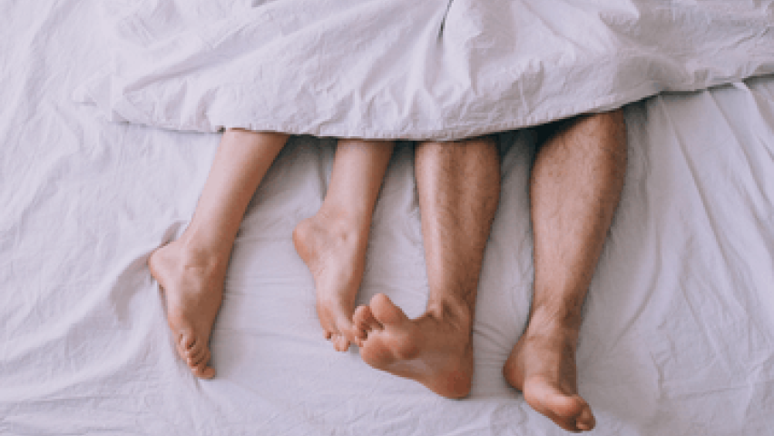 Couple's feet in bed