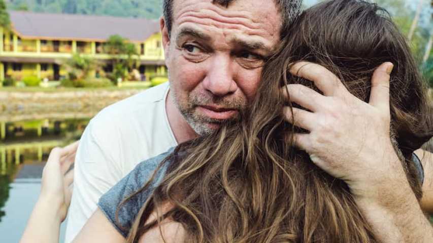 Upset father hugging daughter