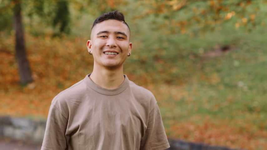 young person smiling in the park