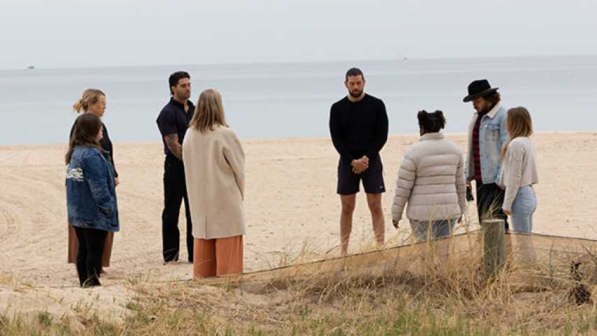 a group of young people standing in a circle at the beach for canteen's national reconciliation week