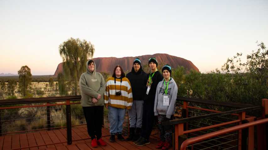 group of young people from Canteen standing in front of Uluru