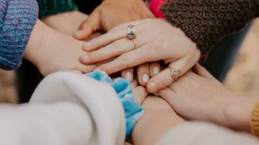 a group of hands joining together as a team