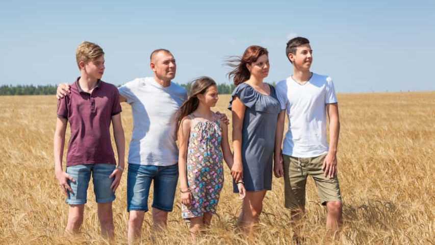 a family impacted by cancer standing together in a field