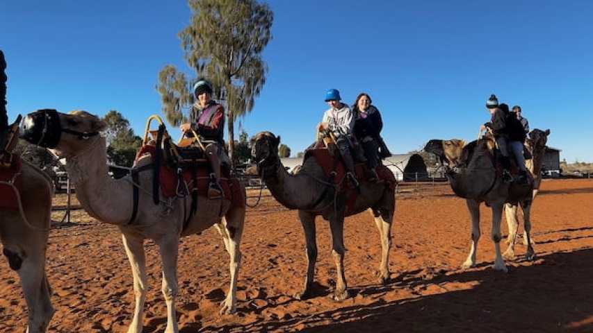 young people riding camels at a canteen event