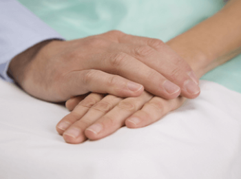 Hands clasping in palliative care