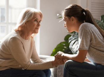 Young woman speaking with her mother about cancer