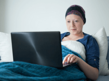 Young woman in hospital bed doing school work