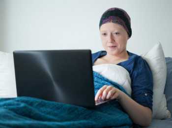 Young woman in hospital bed doing school work